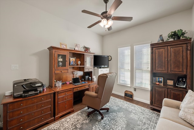 home office with ceiling fan and dark hardwood / wood-style flooring