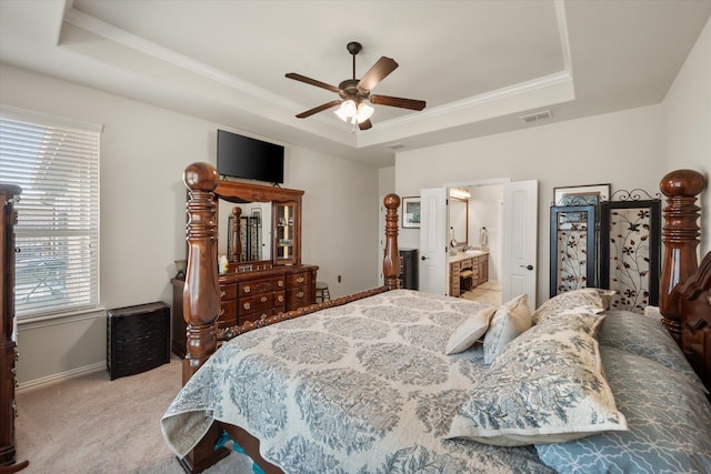 carpeted bedroom with connected bathroom, ceiling fan, and a raised ceiling