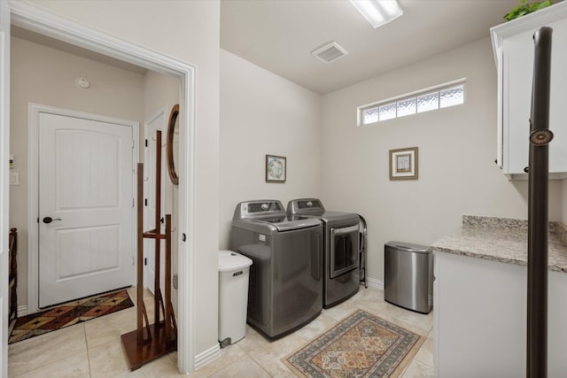 clothes washing area featuring washing machine and dryer and light tile patterned flooring