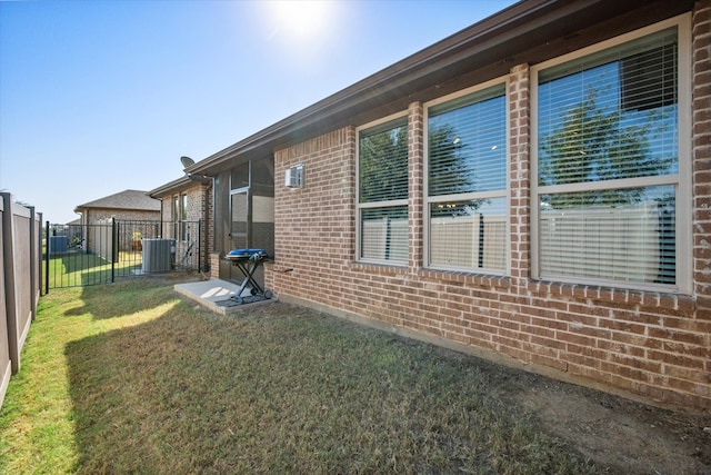 view of side of home with central air condition unit and a lawn