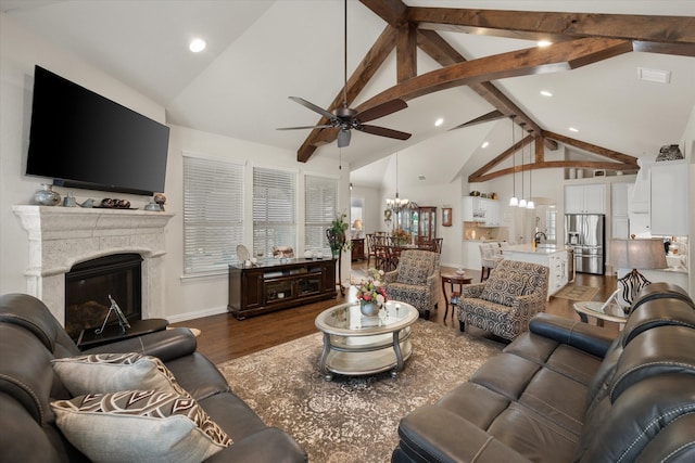 living room with high vaulted ceiling, dark hardwood / wood-style floors, beamed ceiling, ceiling fan with notable chandelier, and sink