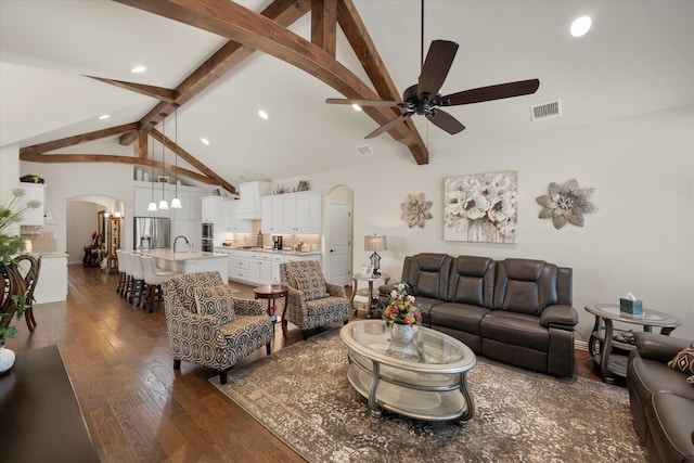 living room with high vaulted ceiling, beamed ceiling, dark hardwood / wood-style flooring, and ceiling fan with notable chandelier