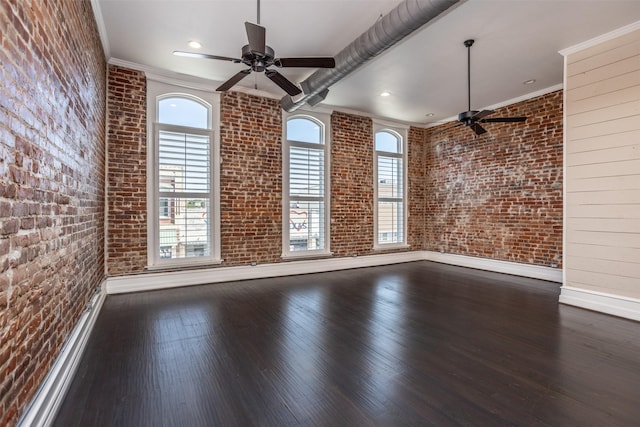 empty room featuring dark hardwood / wood-style floors, ornamental molding, and brick wall