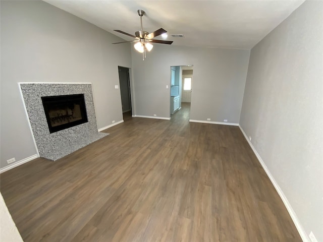 unfurnished living room featuring dark wood-type flooring, vaulted ceiling, and ceiling fan