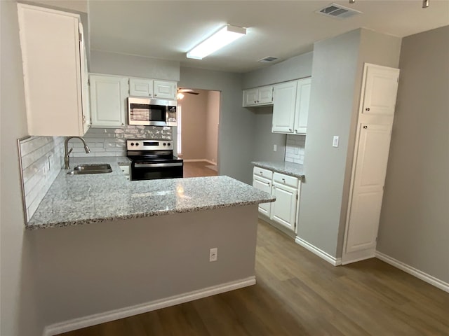 kitchen featuring appliances with stainless steel finishes, kitchen peninsula, white cabinets, and sink