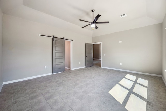 unfurnished bedroom featuring ceiling fan, lofted ceiling, and a barn door