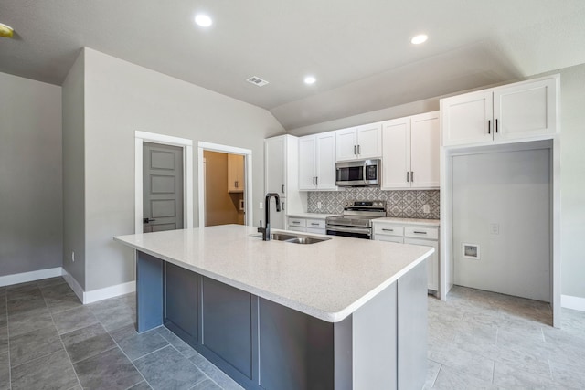 kitchen with tasteful backsplash, a center island with sink, white cabinetry, sink, and stainless steel appliances