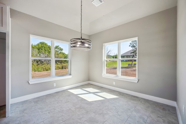 unfurnished dining area featuring a notable chandelier