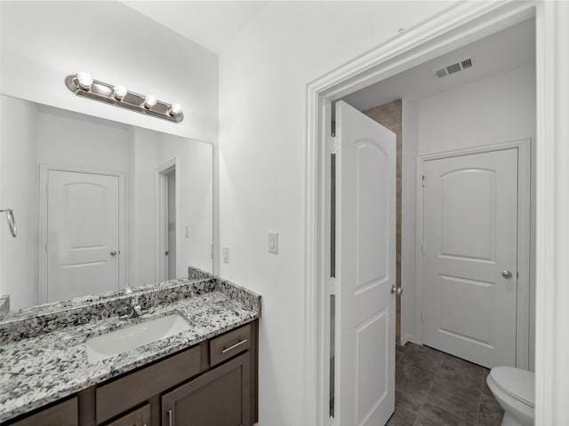 bathroom featuring vanity, toilet, and tile patterned floors