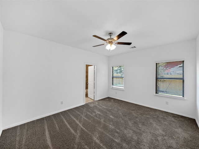 carpeted spare room featuring ceiling fan and plenty of natural light