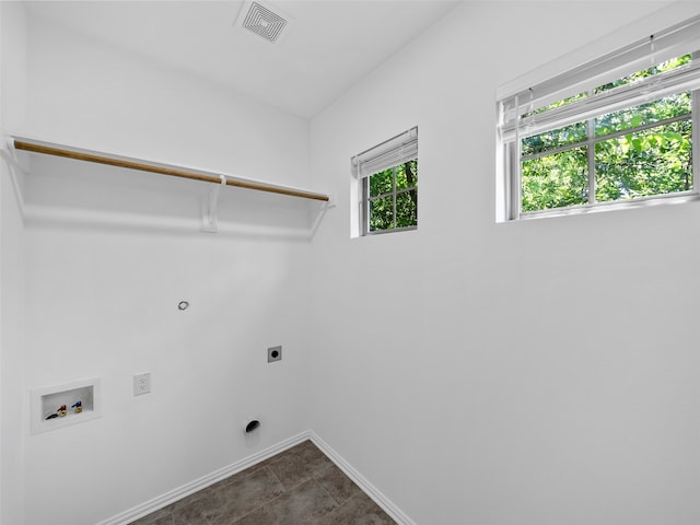 clothes washing area with dark tile patterned floors, electric dryer hookup, and washer hookup