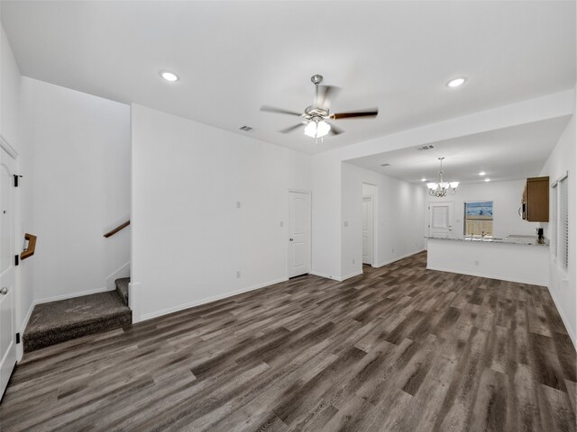 unfurnished living room with dark wood-type flooring and ceiling fan with notable chandelier