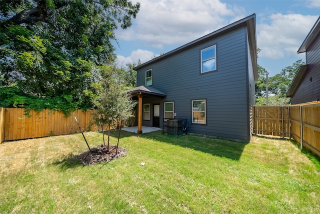 rear view of property featuring a patio area and a lawn