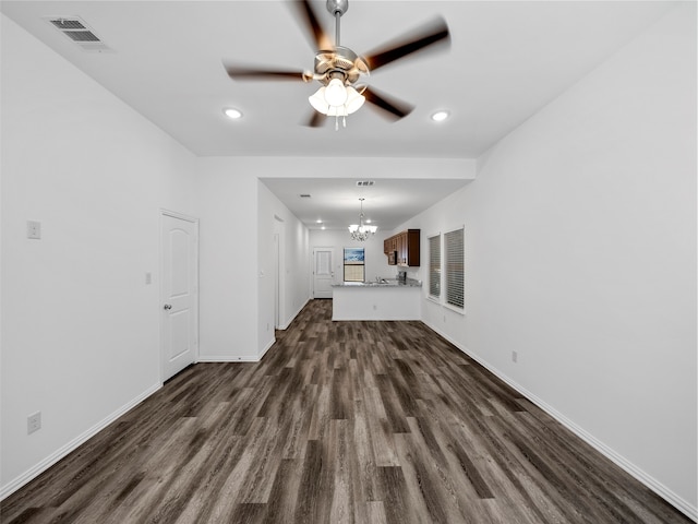 unfurnished living room with dark wood-type flooring and ceiling fan with notable chandelier