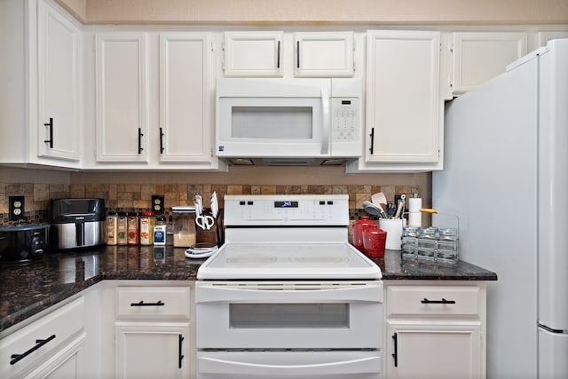 kitchen featuring white appliances, dark stone countertops, and white cabinetry