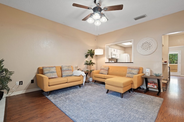 living room with ceiling fan and dark hardwood / wood-style flooring