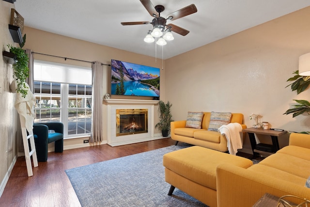 living room with dark wood-type flooring and ceiling fan