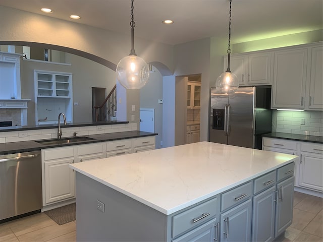 kitchen featuring sink, pendant lighting, stainless steel appliances, and a kitchen island