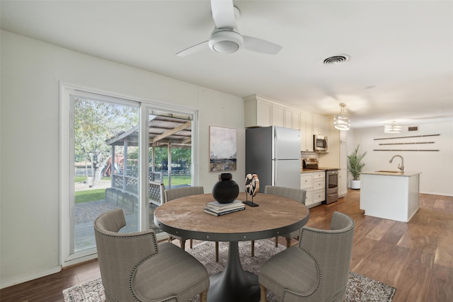 dining space with sink, ceiling fan, and dark hardwood / wood-style flooring