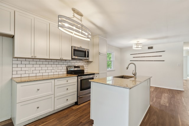 kitchen featuring stainless steel appliances, a center island with sink, sink, pendant lighting, and white cabinetry