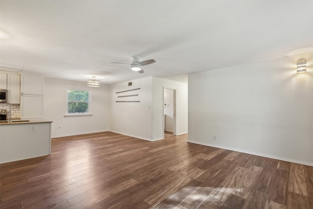 unfurnished living room with ceiling fan, dark hardwood / wood-style flooring, and a fireplace