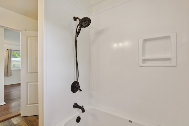 interior details featuring shower / washtub combination and hardwood / wood-style floors