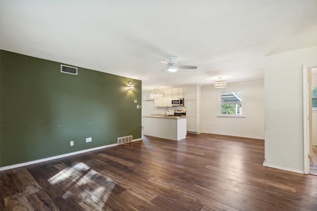 unfurnished living room with ceiling fan and dark hardwood / wood-style flooring