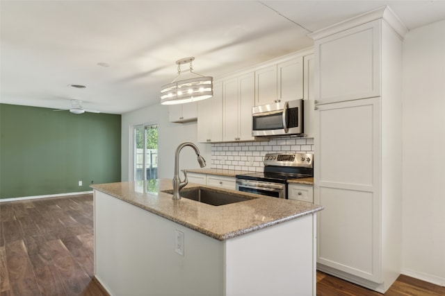 kitchen featuring appliances with stainless steel finishes, sink, an island with sink, hanging light fixtures, and white cabinets