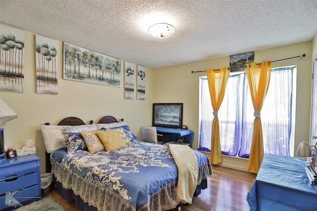 bedroom with hardwood / wood-style floors and a textured ceiling