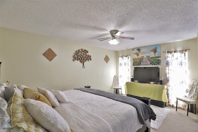 carpeted bedroom with ceiling fan and a textured ceiling