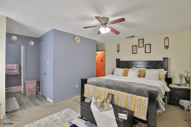 carpeted bedroom with ceiling fan and a textured ceiling