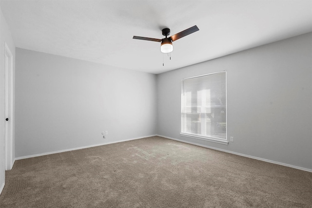 unfurnished room with carpet flooring, ceiling fan, and baseboards