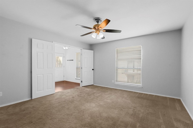 unfurnished bedroom with carpet floors, baseboards, and a ceiling fan