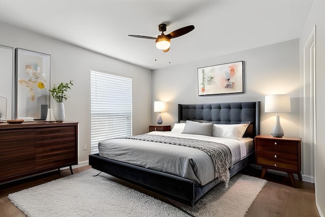 bedroom featuring baseboards, wood finished floors, and a ceiling fan