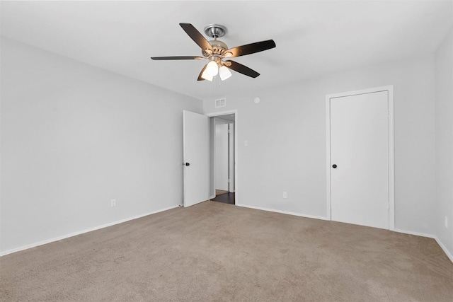 unfurnished bedroom with a ceiling fan, carpet flooring, visible vents, and baseboards