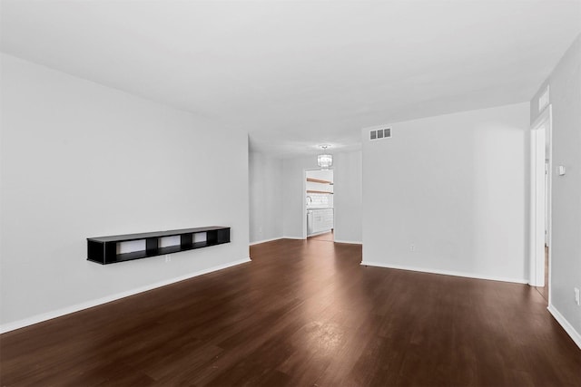 unfurnished living room with wood finished floors and baseboards