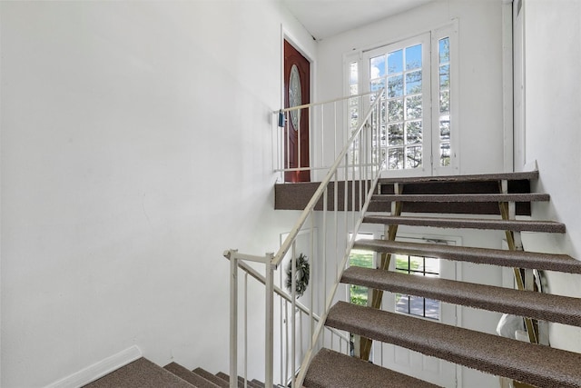 stairs featuring baseboards and carpet flooring