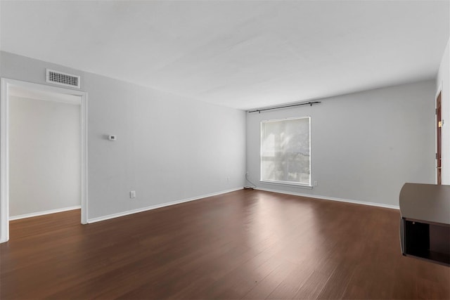spare room featuring wood finished floors and baseboards
