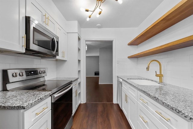 kitchen featuring open shelves, stainless steel appliances, a sink, backsplash, and dark wood-style floors