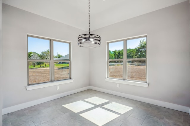 unfurnished dining area with an inviting chandelier