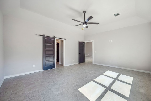 unfurnished bedroom with a barn door and ceiling fan