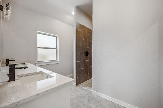 bathroom featuring vanity, tile patterned floors, and tiled shower