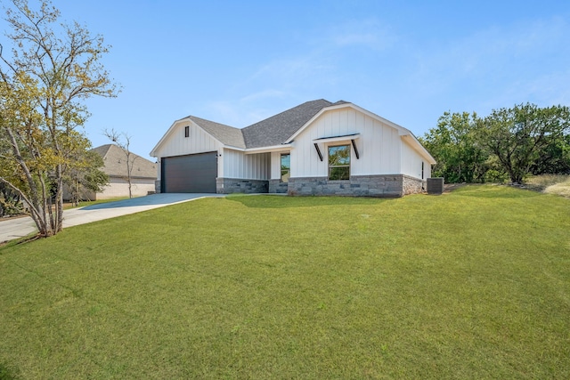 view of front of property featuring a front yard, central AC unit, and a garage