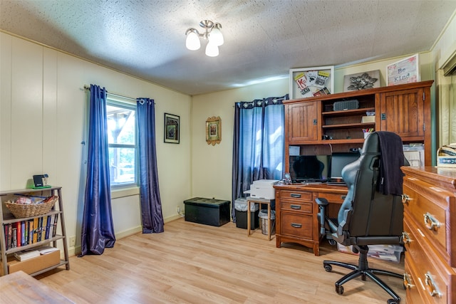 home office featuring a textured ceiling and light wood-type flooring