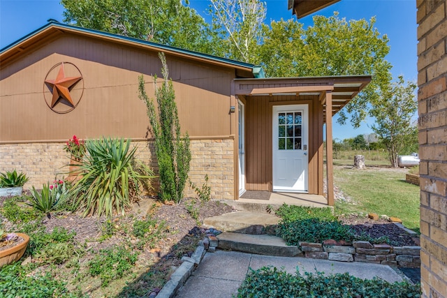 entrance to property featuring a lawn