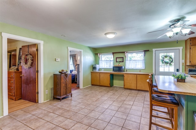 kitchen featuring light tile patterned floors and ceiling fan