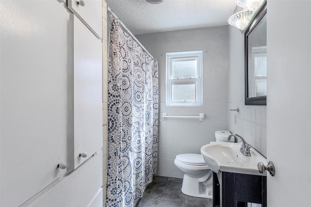 bathroom with a textured ceiling, a shower with shower curtain, toilet, vanity, and tile patterned flooring