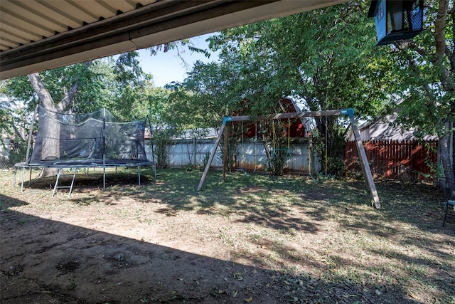 view of yard featuring a trampoline and a playground