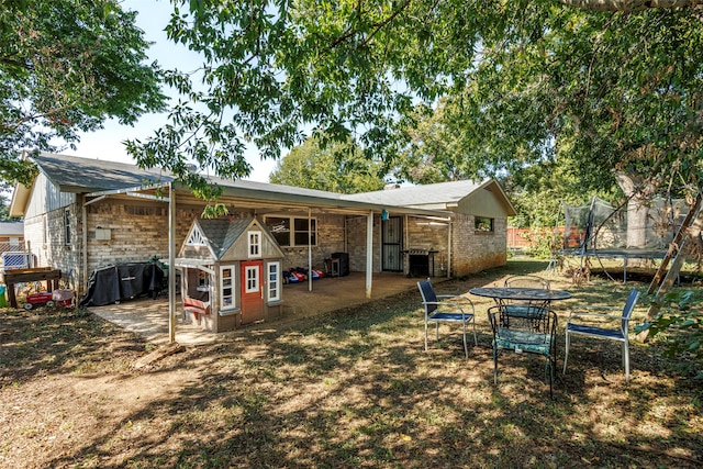 rear view of house with a patio, a trampoline, and central air condition unit