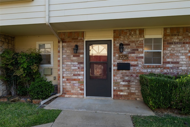 property entrance featuring brick siding